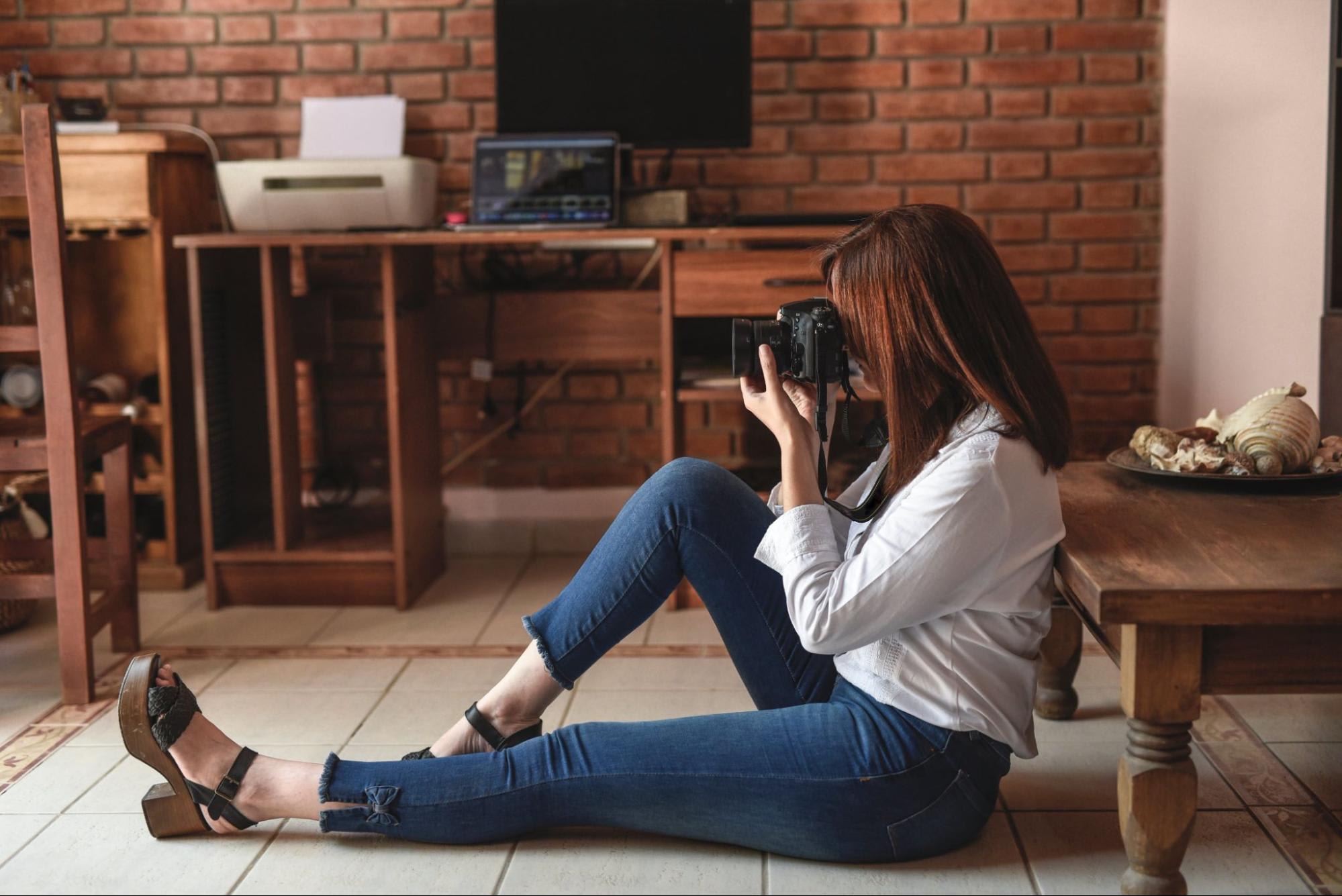 Woman sitting on floor taking a photo
