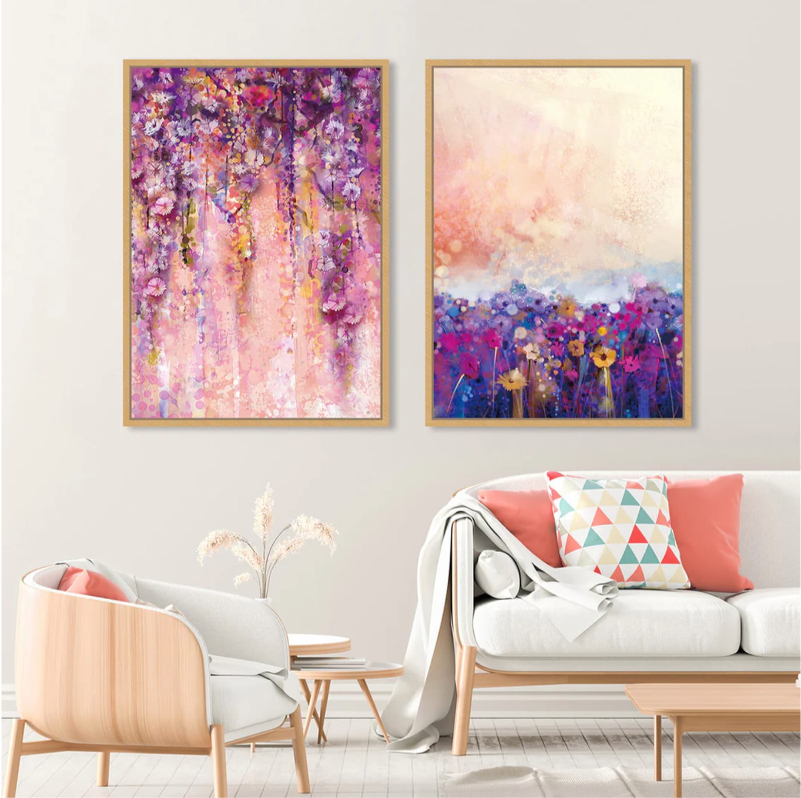 Two abstract floral paintings in wooden frames, hanging above a modern white sofa and a wooden chair