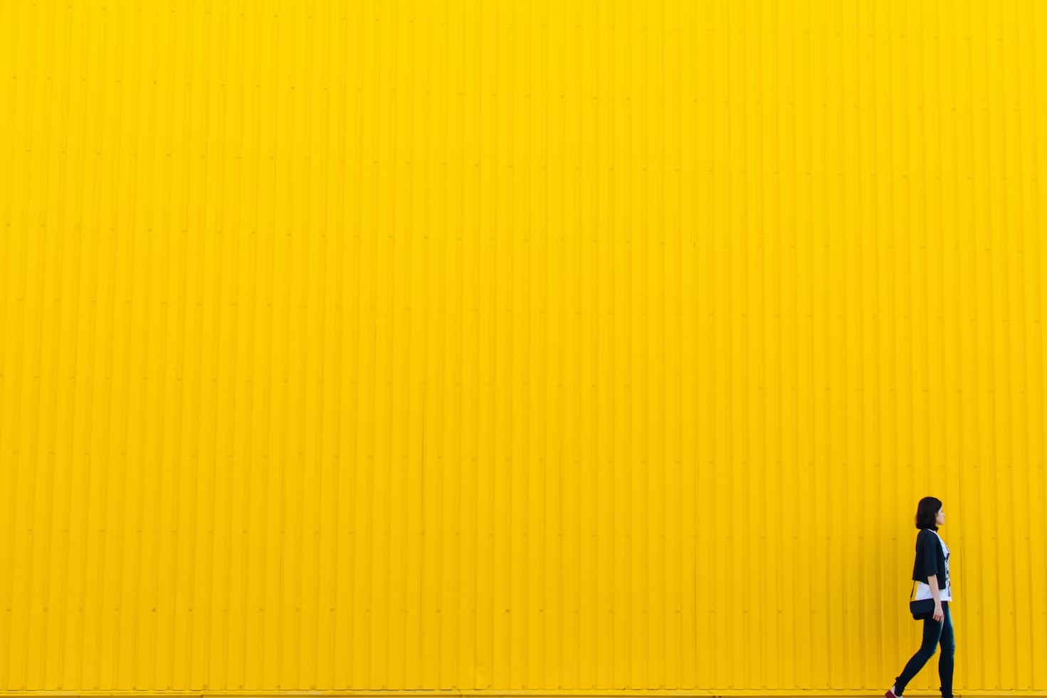 Abstract yellow wall and woman walking across the screen