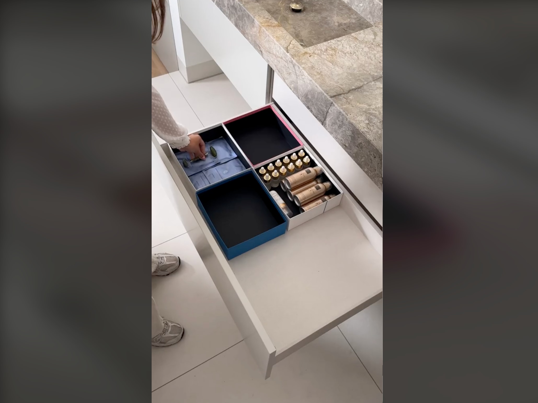 A representative from the Rituals Cosmetics brand reorganizing bathroom drawers