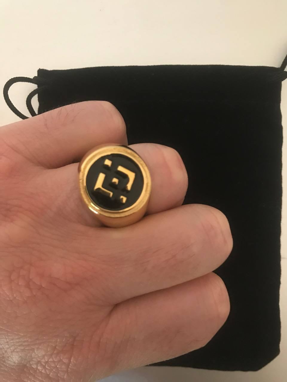 Te vendo un anillo criptográfico de acero inoxidable con una bolsa negra.