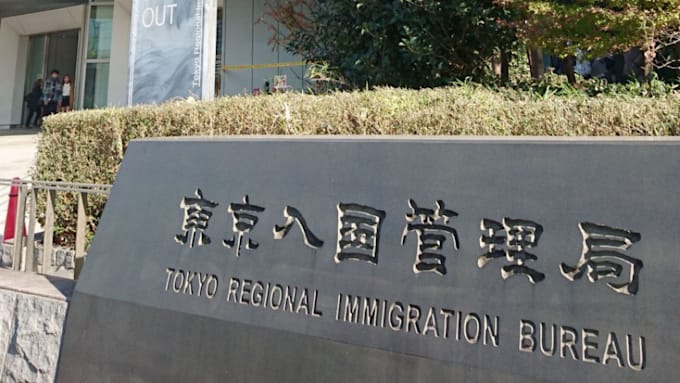 A Japanese immigration office building with a sign in Japanese and English.