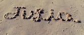 write your text on sand with natural shells and beach stones