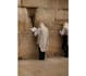 placing a prayer note between the stones of the western wall kotel