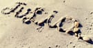 write your text on sand with natural shells and beach stones