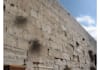 placing a prayer note between the stones of the western wall kotel