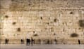 placing a prayer note between the stones of the western wall kotel