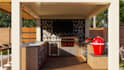 design an outdoor living space with kitchen, BBQ and pergola