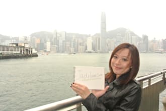 take photos holding your sign in front Victoria Harbour, Hong Kong