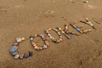 create a wonderful photo using stones in the beach with your message