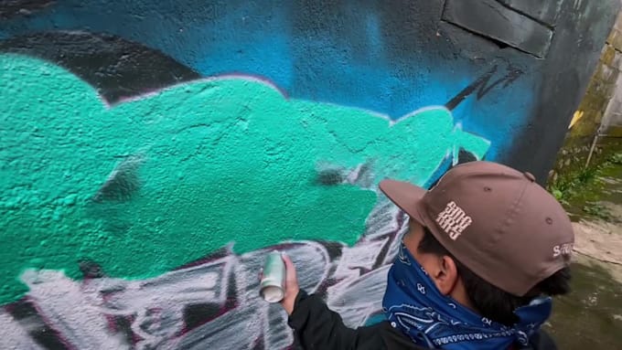 paint real graffiti art on the street wall